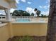 Community pool featuring white lounge chairs and lush greenery with a clear blue sky at 6030 Dijulio Ter, The Villages, FL 32163