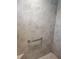 Updated shower features grey stone tiles, a grab bar, and a built-in bench at 6030 Dijulio Ter, The Villages, FL 32163