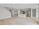 Open-concept living area with light wood floors that flows into the kitchen with stainless steel appliances at 1620 Ellesmere Ave, Haines City, FL 33844