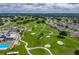 Scenic aerial view of the community golf course, pool, and clubhouse amidst well-maintained landscaping at 6229 Raven Run, Lakeland, FL 33809