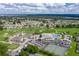 Stunning aerial view of the community clubhouse, pool, tennis courts, and lush golf course on a sunny day at 6229 Raven Run, Lakeland, FL 33809