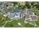 Stunning aerial view of community amenities including a pool, tennis courts, shuffleboard, golf course, and community center at 6229 Raven Run, Lakeland, FL 33809