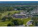Aerial view of golf course community with clubhouse, golf cart parking, pool, and tennis courts at 6229 Raven Run, Lakeland, FL 33809