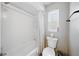 Bathroom features a white tiled shower and bath with a white toilet at 6229 Raven Run, Lakeland, FL 33809