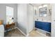 Bright bathroom with a large mirror, blue vanity, and door to the bedroom with a ceiling fan at 6229 Raven Run, Lakeland, FL 33809