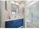 Bathroom with a bright mirror, blue vanity with white counter, and glass shower doors at 6229 Raven Run, Lakeland, FL 33809