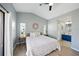 This bedroom includes an en-suite bathroom, neutral walls, modern ceiling fan, and wood-look floors at 6229 Raven Run, Lakeland, FL 33809
