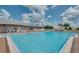 Large community pool with clear blue water, lounge chairs, and a building for a pleasant outdoor experience at 6229 Raven Run, Lakeland, FL 33809