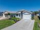 Well-maintained home with an attached garage, attractive landscaping, and a large driveway at 6229 Raven Run, Lakeland, FL 33809