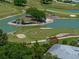 Picturesque golf course view featuring lush greens, sand traps, and a tranquil pond with players on the green at 6229 Raven Run, Lakeland, FL 33809