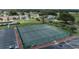 Aerial view of pristine tennis courts surrounded by lush greenery and neighborhood homes at 6229 Raven Run, Lakeland, FL 33809