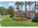 Kingsbridge West brick entrance sign with manicured flower bed and mature palm trees on a sunny day at 917 Keep Way Loop, Oviedo, FL 32765