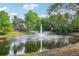 Scenic view of pond with central fountain surrounded by lush trees and landscaping at 917 Keep Way Loop, Oviedo, FL 32765