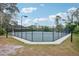 Well-maintained tennis court with dark fences surrounded by lush landscaping at 917 Keep Way Loop, Oviedo, FL 32765