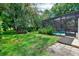 Spacious backyard featuring a screened-in pool area, lush landscaping, and a stone paver entrance at 917 Keep Way Loop, Oviedo, FL 32765