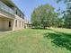Expansive backyard with lush green grass, mature tree and partial fence provides ample space for outdoor activities at 1705 Plantation Pointe Dr, Orlando, FL 32824