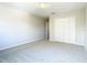 This bedroom features neutral walls, plush carpeting, and a double door closet, for ample storage space at 1705 Plantation Pointe Dr, Orlando, FL 32824