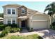 Charming two-story home featuring a stone facade, well-manicured landscaping, and a brick driveway at 1705 Plantation Pointe Dr, Orlando, FL 32824
