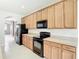 Bright kitchen features light wood cabinets, black appliances, and tile backsplash at 1705 Plantation Pointe Dr, Orlando, FL 32824