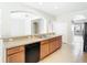 Functional kitchen with sink, breakfast bar, wood cabinets, black appliances, and tile floors at 1705 Plantation Pointe Dr, Orlando, FL 32824