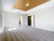 Spacious main bedroom featuring tray ceiling, neutral carpet, and ensuite bathroom access at 1705 Plantation Pointe Dr, Orlando, FL 32824