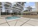 A view of the pool, spa, and surrounding neutral patio inside the screened enclosure at 2170 Lake Marion Dr, Apopka, FL 32712