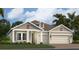 Charming single-Gathering home with symmetrical curb appeal, a tidy lawn, and an attached two-car garage at 2203 Rider Rain Ln, Apopka, FL 32703