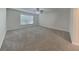 An empty bedroom with a neutral color scheme is brightly lit with a ceiling fan and large window at 105 Evergreen Dr, Auburndale, FL 33823