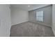 A well lit bedroom provides a comfortable space, complete with a large window and plush gray carpeting at 105 Evergreen Dr, Auburndale, FL 33823
