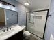 Well-lit bathroom showcases a modern vanity, fixtures, and a glass-enclosed shower with blue accent wall at 11757 Se 71St Terrace Rd, Belleview, FL 34420