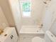 Bright bathroom featuring a bathtub with modern fixtures and a window, complemented by stylish vanity and toilet at 1960 Hamilton St, Bartow, FL 33830