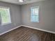 Bedroom featuring wood floors, two large windows, and neutral-toned walls at 1960 Hamilton St, Bartow, FL 33830