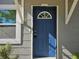 Close-up of a blue front door with decorative window, set against a gray exterior with white trim at 1960 Hamilton St, Bartow, FL 33830