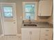 Laundry space featuring a stainless steel sink, granite countertop, and white cabinets at 1960 Hamilton St, Bartow, FL 33830