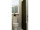 Bathroom with toilet, white tiles, olive green shower curtain, and a bright window, showcasing a clean design at 2934 Haze Rd, Clermont, FL 34714