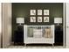 Charming Bedroom featuring a white crib, animal-themed artwork, and classic wooden dressers at 2934 Haze Rd, Clermont, FL 34714