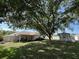 Large backyard features a covered patio, mature trees, shed, and white fencing at 3210 Se 54Th Cir, Ocala, FL 34480
