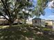 Large backyard features mature trees, a shed, a fire pit, and concrete statues at 3210 Se 54Th Cir, Ocala, FL 34480