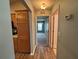 Hallway leading to a bedroom with light green walls and wood-look flooring and access to kitchen at 3210 Se 54Th Cir, Ocala, FL 34480