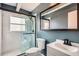 Bathroom with shower behind a glass door, modern sink, mirror, and blue walls at 3026 Pinedale Ave, Lakeland, FL 33803
