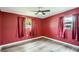 Red bedroom with hardwood floors, two windows, and matching red curtains at 3026 Pinedale Ave, Lakeland, FL 33803