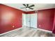 Bedroom with red walls, wood-look flooring, ceiling fan, closet, and bathroom access at 3026 Pinedale Ave, Lakeland, FL 33803