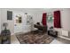 Staged bedroom features a desk, rug, neutral decor, and a window with red curtains at 3026 Pinedale Ave, Lakeland, FL 33803