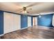 Spacious blue bedroom featuring wood-look floors, a ceiling fan, and a closet at 3026 Pinedale Ave, Lakeland, FL 33803