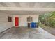 The carport has a bright red door and a convenient concrete slab for parking and storage at 3026 Pinedale Ave, Lakeland, FL 33803