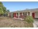 Single-story brick home featuring a bright red front door, white accents, and a covered carport at 3026 Pinedale Ave, Lakeland, FL 33803