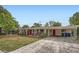 Lovely single-story brick home with a bright red door and a convenient covered parking area at 3026 Pinedale Ave, Lakeland, FL 33803