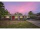 Charming single-story brick home featuring a vibrant red front door and covered carport at 3026 Pinedale Ave, Lakeland, FL 33803