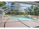 This screened-in pool features a waterfall rock feature, a large yard, and a patio at 3690 Sw 175Th St, Ocala, FL 34473