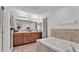 Bright bathroom features a double vanity, large mirror, soaking tub, and wood look floors at 513 Kimbrel Ct, Haines City, FL 33844